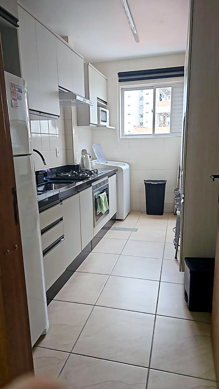 Cocina con horno, anafe y área de servicio con lavarropas