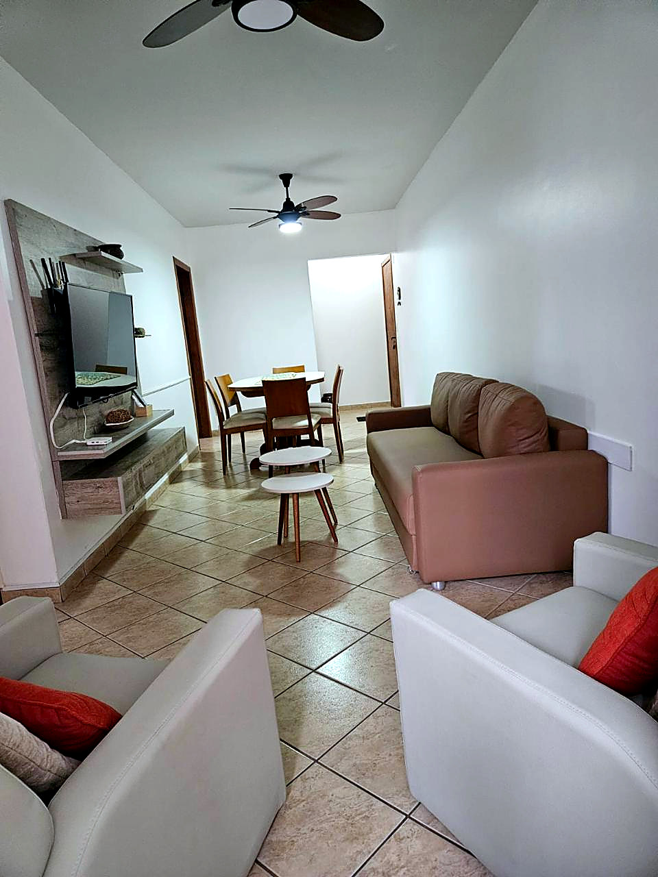 Living con sillones, televisor y mesa de comedor al fondo